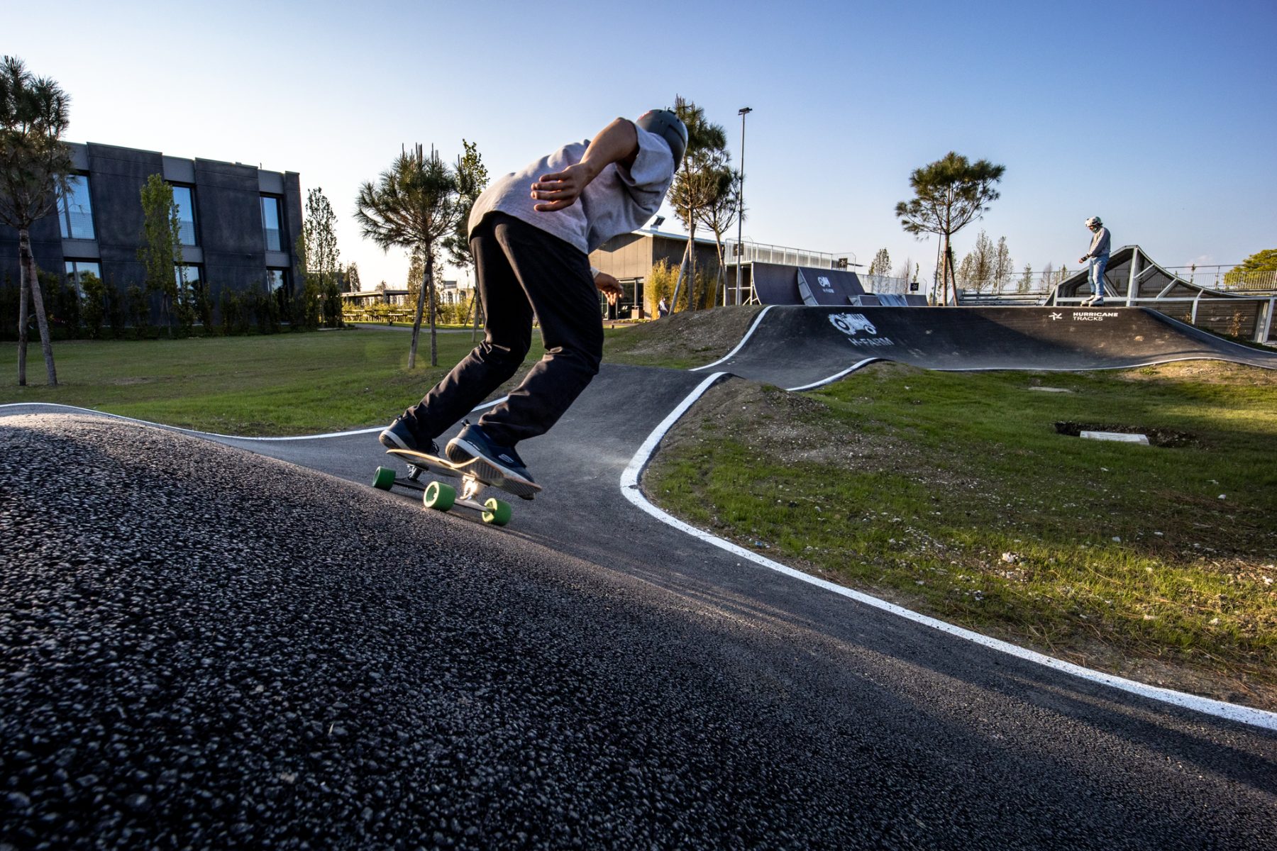 A student skating the pump track on H-FARM Campus at sunset